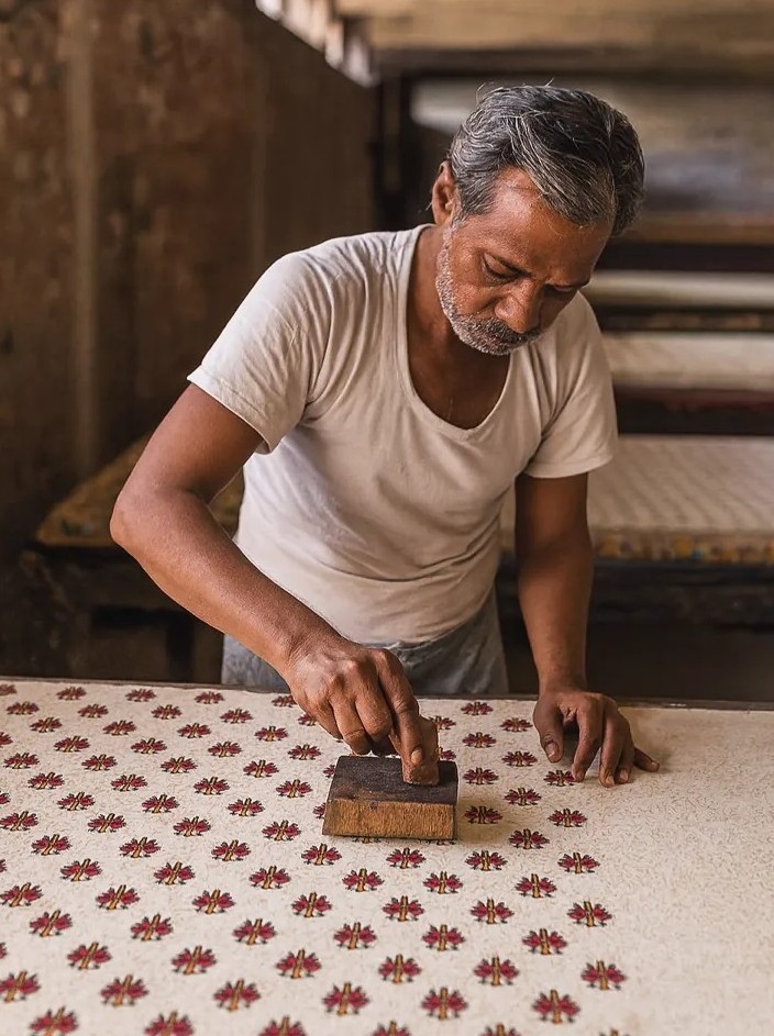 Master artisan hand block printing traditional patterns on fabric