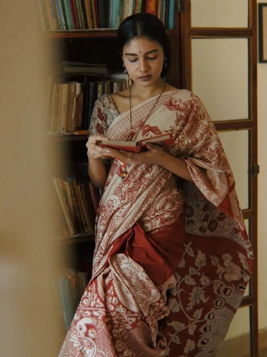 Skilled craftswoman carefully inspecting handwoven saree fabric